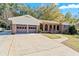 A long driveway leading to a brick home with a 2-car garage and an arched brick porch at 6418 Briarwood Ct, Riverdale, GA 30296