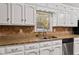 Kitchen close-up features granite countertops, stainless steel dishwasher and white cabinets at 6418 Briarwood Ct, Riverdale, GA 30296