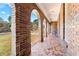 Inviting arched brick porch with mosaic tile flooring and seating area at 6418 Briarwood Ct, Riverdale, GA 30296