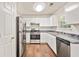 Well-lit kitchen with stainless steel appliances, white cabinets, and modern fixtures at 2240 Creekside Vw, Decatur, GA 30035
