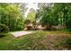 Mature trees frame a spacious backyard with a wooden deck and a concrete pad for outdoor enjoyment at 4324 Japonica Sw Ct, Lilburn, GA 30047
