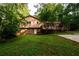 An expansive backyard features lush green grass, mature trees, a wooden deck, and a concrete pad at 4324 Japonica Sw Ct, Lilburn, GA 30047