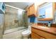 Bathroom featuring a tub and shower with glass doors, granite countertop, and wooden cabinets at 4324 Japonica Sw Ct, Lilburn, GA 30047