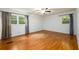 Sunlit bedroom showcasing hardwood floors, large windows, and neutral wall color at 4324 Japonica Sw Ct, Lilburn, GA 30047