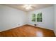 A bedroom features hardwood flooring and a large window showcasing the natural light and lush greenery outside at 4324 Japonica Sw Ct, Lilburn, GA 30047