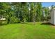 Expansive backyard with lush green lawn and mature trees, offering privacy and space for outdoor activities at 4408 Brandon Ne Ct, Marietta, GA 30066