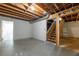 Unfinished basement with exposed wooden ceiling beams and access to wooden staircase at 4408 Brandon Ne Ct, Marietta, GA 30066