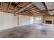 Unfinished basement with exposed ceiling, concrete floor, and painted brick fireplace offers renovation potential at 143 Longview Rd, Fayetteville, GA 30214