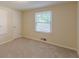 This bedroom with carpet features a bright window and is painted in neutral tones at 143 Longview Rd, Fayetteville, GA 30214