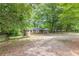 A quaint brick home with classic white shutters, nestled amongst large shade trees and ample open space at 143 Longview Rd, Fayetteville, GA 30214