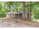 Charming brick home featuring white shutters and a covered front porch nestled among mature trees at 143 Longview Rd, Fayetteville, GA 30214