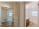 Hallway with wood flooring that transitions to a room with carpet and a partial view of the bathroom at 143 Longview Rd, Fayetteville, GA 30214