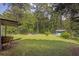 Spacious backyard with mature trees, lush lawn, a fire pit, and a storage shed offering a serene outdoor setting at 4002 Phylis Pl, Decatur, GA 30035