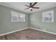 This cozy bedroom features a ceiling fan, two windows, and light green painted walls at 4002 Phylis Pl, Decatur, GA 30035