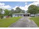 Traditional home with a long driveway, mature trees, a carport, and a well-maintained lawn at 4002 Phylis Pl, Decatur, GA 30035