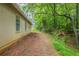 View of the house's backyard featuring a dirt area adjacent to the lush green trees at 5856 Rock Rd, Union City, GA 30291