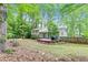 Beautifully landscaped backyard with a well-maintained lawn, wood deck, and lush trees at 604 Continental Dr, Lawrenceville, GA 30044