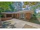 Brick home exterior featuring double doors, covered entry, and concrete patio in a wooded lot at 148 Hurt Road Sw, Smyrna, GA 30082