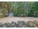 Large backyard featuring a shed and playset surrounded by mature trees at 148 Hurt Road Sw, Smyrna, GA 30082