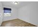 Simple bedroom with wood-look floors, a window with blinds, and closet at 148 Hurt Road Sw, Smyrna, GA 30082