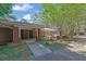 Exterior elevation featuring a brick facade, covered entryway, and mature trees at 148 Hurt Road Sw, Smyrna, GA 30082