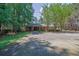 Front exterior with a brick facade, a large driveway and mature trees at 148 Hurt Road Sw, Smyrna, GA 30082