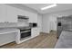 Well-lit kitchen with white cabinets, stainless steel appliances, and wood-look flooring at 148 Hurt Road Sw, Smyrna, GA 30082
