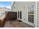 Wooden back deck offering space for outdoor seating with adjacent white siding and large window at 1608 Indian Way, Cumming, GA 30040
