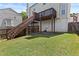 Large backyard features a well-maintained lawn, deck with stairs, and mature trees at 1608 Indian Way, Cumming, GA 30040