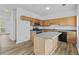 Modern kitchen with hardwood floors, light wood cabinetry, stainless steel appliances, and functional center island at 1608 Indian Way, Cumming, GA 30040