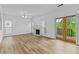 Bright living room with fireplace, ceiling fan, wood flooring and access to outdoor deck through double doors at 1608 Indian Way, Cumming, GA 30040
