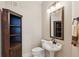 Stylish half-bathroom with pedestal sink, unique corner shelving and elegant mirror at 3621 Vinings Slope Se # 3510, Atlanta, GA 30339