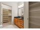 Bathroom with wooden vanity and walk in closet with shelving at 3621 Vinings Slope Se # 3510, Atlanta, GA 30339