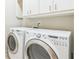 Laundry room featuring modern washer and dryer with white cabinets at 3621 Vinings Slope Se # 3510, Atlanta, GA 30339
