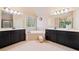 Bathroom featuring double vanities, a soaking tub, and natural light at 5285 Winflow Way, Suwanee, GA 30024