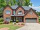 Beautiful brick home featuring a well-manicured lawn and a two-car garage at 5285 Winflow Way, Suwanee, GA 30024