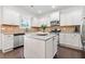 Well-lit kitchen showcasing white cabinets, granite countertops, and stainless steel appliances at 5285 Winflow Way, Suwanee, GA 30024