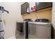 Laundry room featuring a new washer and dryer, and overhead shelving at 5285 Winflow Way, Suwanee, GA 30024