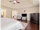Bright main bedroom boasts a ceiling fan, sitting area, and dark hardwood floors at 5285 Winflow Way, Suwanee, GA 30024