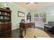 Stylish office with dark wood furniture, hardwood floors, and bright window at 5285 Winflow Way, Suwanee, GA 30024