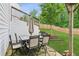 Charming back patio with an outdoor dining set and a lush green lawn at 6360 Boulder Rdg, Cumming, GA 30028