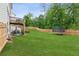 Large backyard with a well-maintained lawn, privacy fence, and trampoline at 6360 Boulder Rdg, Cumming, GA 30028