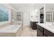 Luxurious bathroom with a soaking tub, tiled shower, and dual vanities at 6360 Boulder Rdg, Cumming, GA 30028