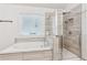 Luxurious bathroom with a soaking tub and tiled shower at 6360 Boulder Rdg, Cumming, GA 30028