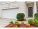 Close up of a home's entrance showcasing a brick exterior, manicured landscaping and a two-car garage at 6360 Boulder Rdg, Cumming, GA 30028