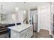 Open-concept kitchen with an island, stainless steel appliances, and seamless flow to the dining area at 6360 Boulder Rdg, Cumming, GA 30028