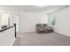 Second story living room features a gray two-seater reclining couch and neutral carpet at 6360 Boulder Rdg, Cumming, GA 30028