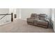 Second story living room features a gray two-seater reclining couch and neutral carpet at 6360 Boulder Rdg, Cumming, GA 30028