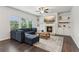 Cozy living room features a fireplace, built-in shelves, a plush sofa, and lots of natural light at 6360 Boulder Rdg, Cumming, GA 30028