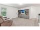 Cozy living room features a comfortable recliner, built-in bookshelves, and a large TV at 6360 Boulder Rdg, Cumming, GA 30028